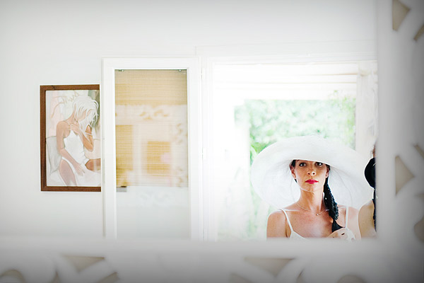 Mariée en chapeau devant un miroir